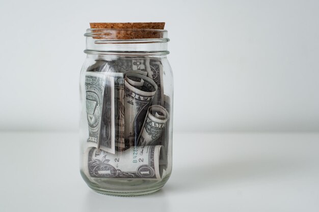 One hundred dollar bills in glass jar