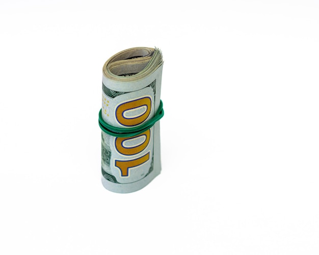 Photo one hundred dollar bills rolled into a tube isolated on white background