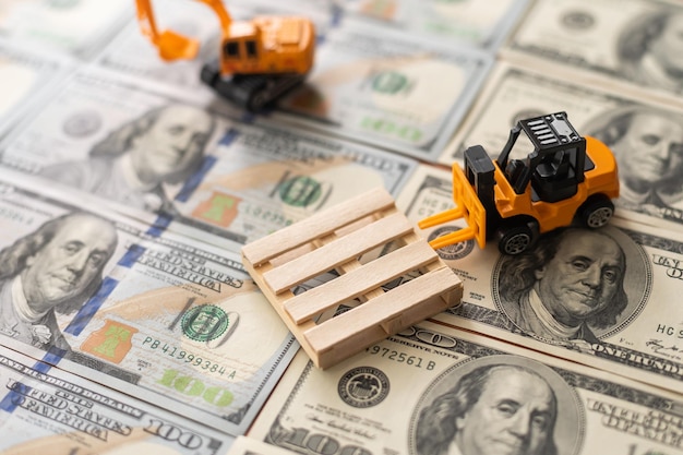 One hundred dollar bills and a toy excavator