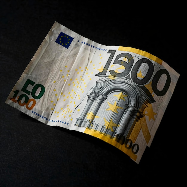 one hundred euro banknote behind wave carved on a black background