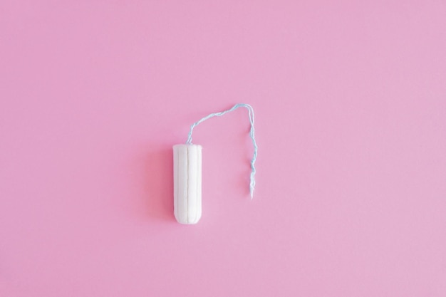 One hygienic tampon on a pink background Menstrual mothly cycle means of protection