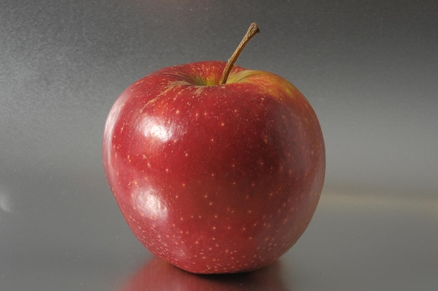 One Juicy Hot Red Apple over a Colored Background