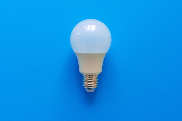 One light bulb on a blue paper background