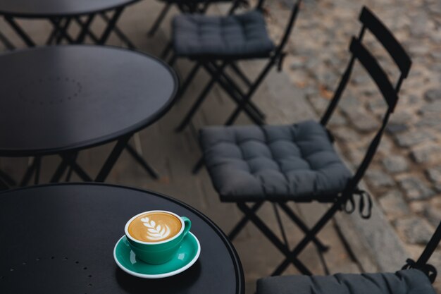 One light green mug of freshly brewed aroma cappuccino with heart shape