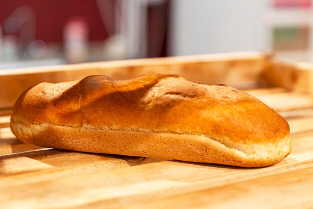 One loaf of bread on a wooden counter in a store Closeup