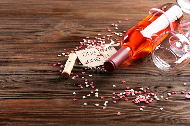 Foto un amore, un concetto di vita: bottiglia di vino e bicchieri con cuori intorno