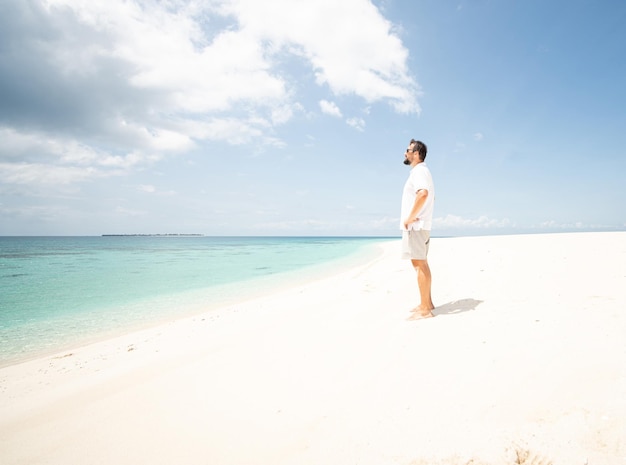 Un uomo sta godendo di una bellissima spiaggia tropicale
