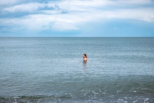 One man swims in the sea in summer