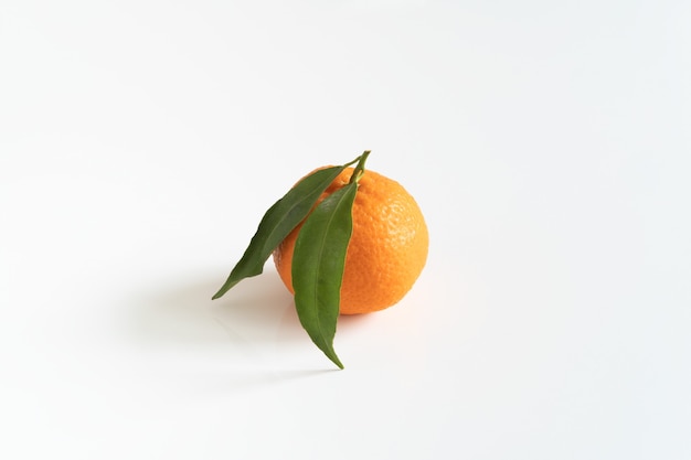 One mandarin or tangerine with a green leaf  