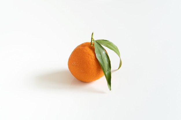 One mandarin or tangerine with a green leaf  