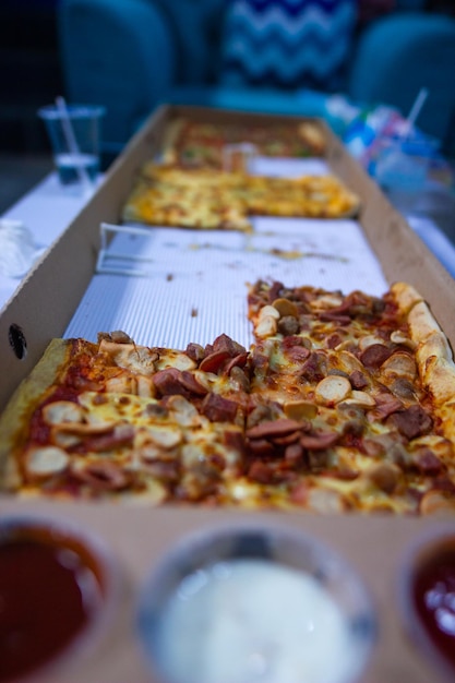 1 メートルの長いピザ。白いテーブルの上に長いピザ ミックスがあります。