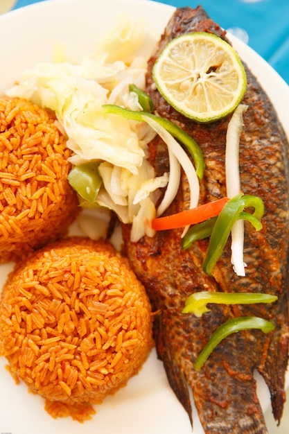 Uno dei cibi più popolari in ghana, il riso jollof, servito con il pesce