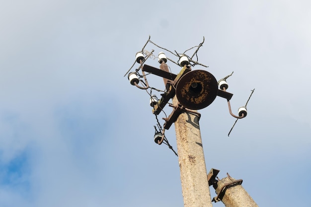 One old concrete street pole with a rusty iron part at the top
and cut wires installation or dismantling of the power grid a
broken energy pillar