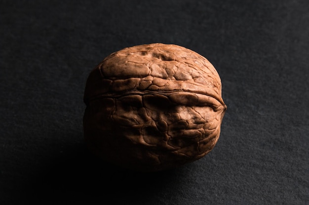 One open walnut on black slate background