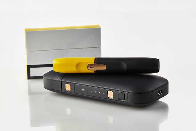 1パックの新世代の黒と黄色の電子タバコは白いハイテックで隔離されたバッテリーにあります