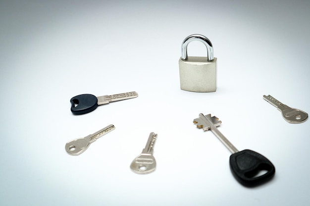 Foto un lucchetto con molte altre chiavi molte chiavi e una serratura come concetto diverse chiavi di metallo e un lucchetto d'acciaio a cerniera su uno sfondo bianco