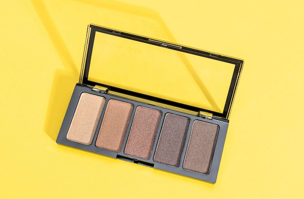 One palette of nude eyeshadows on yellow