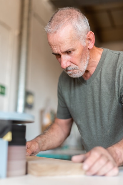 One person sanding the edge of a wooden step