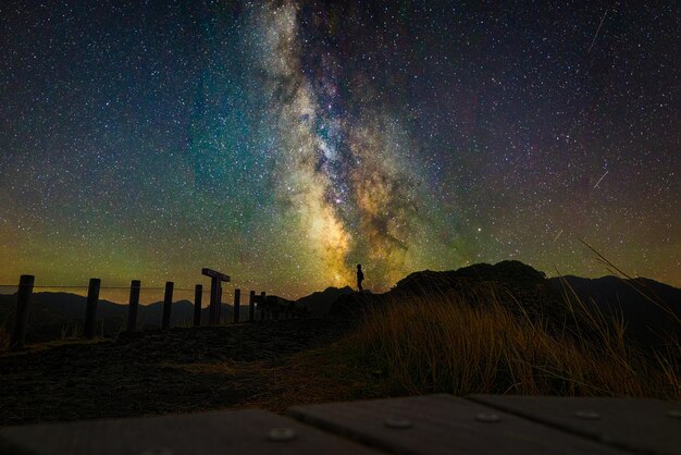 Photo one person standing on the summit and starry sky at ogasawara