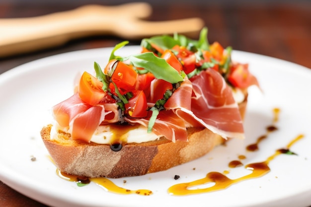 One piece of prosciutto bruschetta placed on a small serving dish