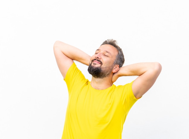 One positive man with yellow shirt portrait against wall