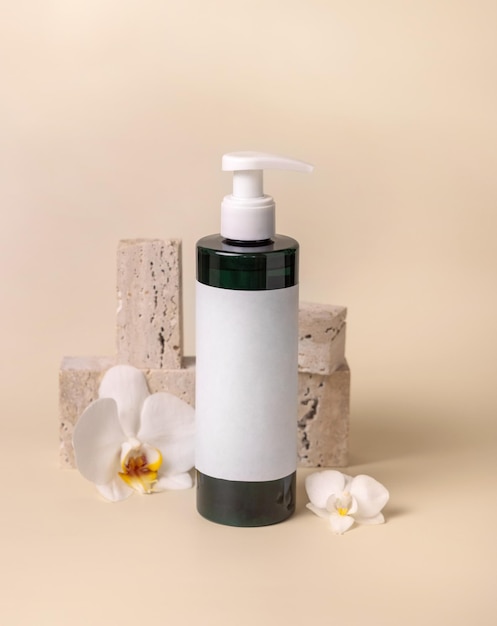 One pump bottle near white orchid flower and stones on light beige Mockup