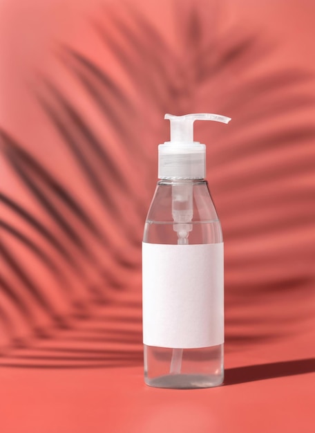 One pump Plastic bottle with blank label on pink Palm leaf hard shadows Mockup