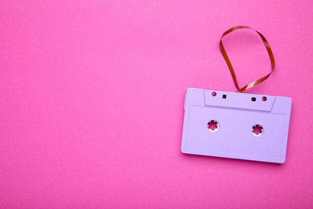 One purple cassette on a pink background. Music day