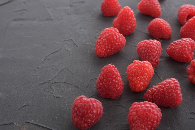 One raspberry on a beautiful dark concrete textured table.