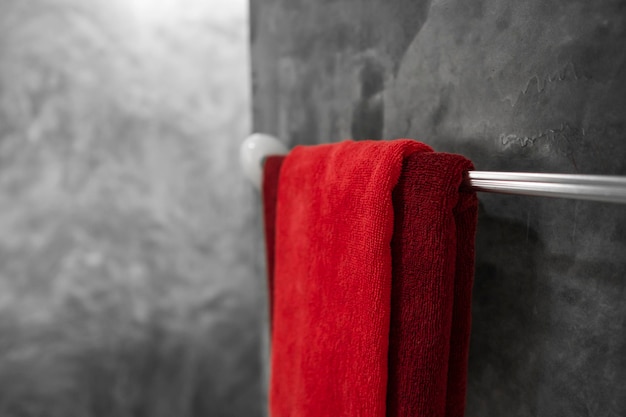 One red towel in bathroom on a dryer