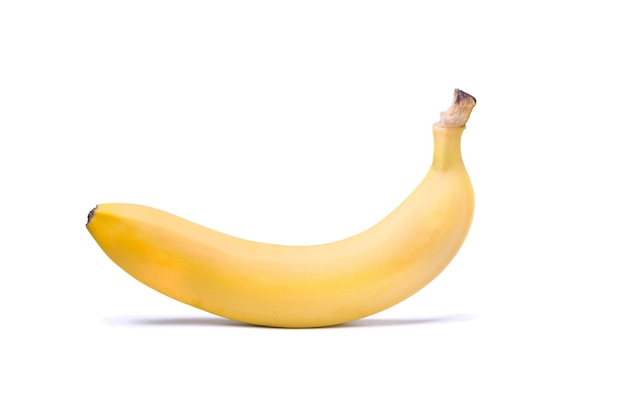 Один спелый желтый банан на белом фоне