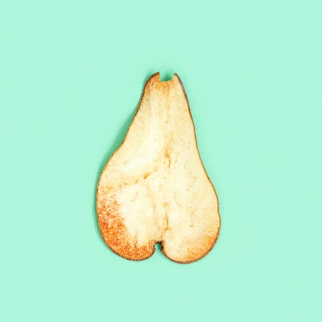 One slice of dried  fruits pear on mint color background Dehydrated fruit chips