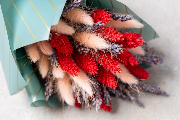 One small bouquet of lavender with lagurus in turquoise packaging .