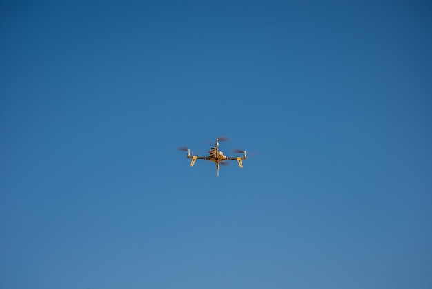 one small drone with blue sky on background.