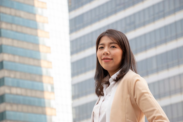 One smiling business woman with building background.