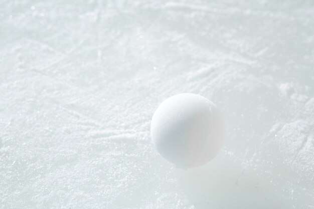 One snowball lies on the surface of the ice on a sunny frosty winter day