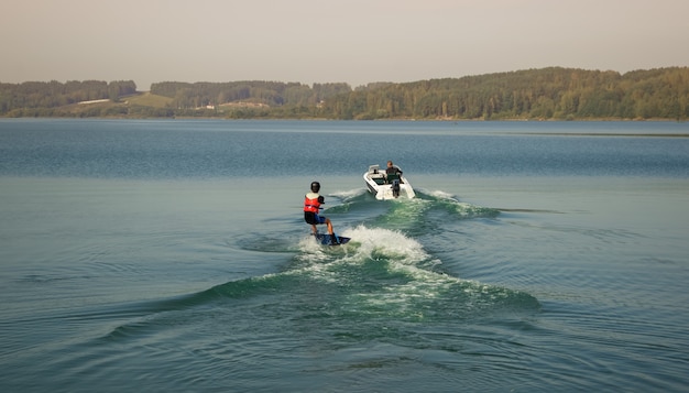 One sportsman wakeboarder rides behind a boat