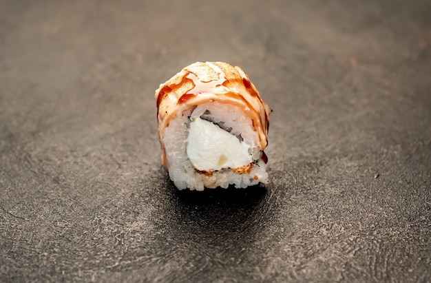 one sushi roll on a stone background