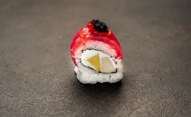 石の背景に1つの巻き寿司