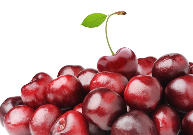 One sweet cherry with leaf on top of a cherries pile isolated on white