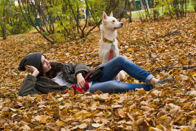 犬と一緒に地面に横たわっている10代の女の子