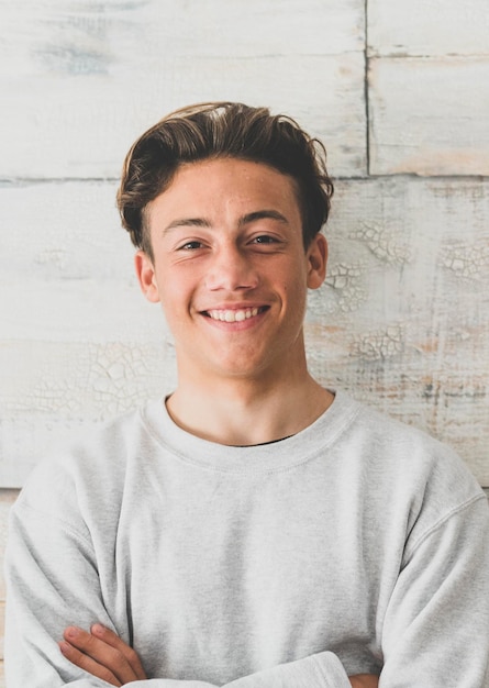 Foto un adolescente a casa sorridendo felice alla fotocamera semplice foto di un bel giovane