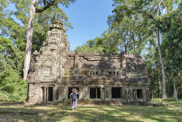 One tourist visiting Angkor ruins amid jungle