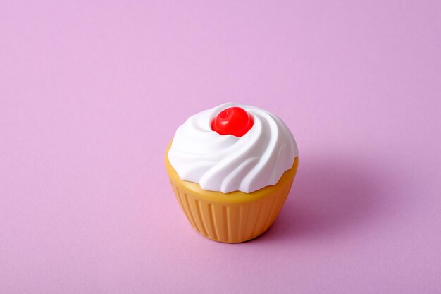 One toy cupcake with whipped cream and cherries on pink background confectionery delivery concept