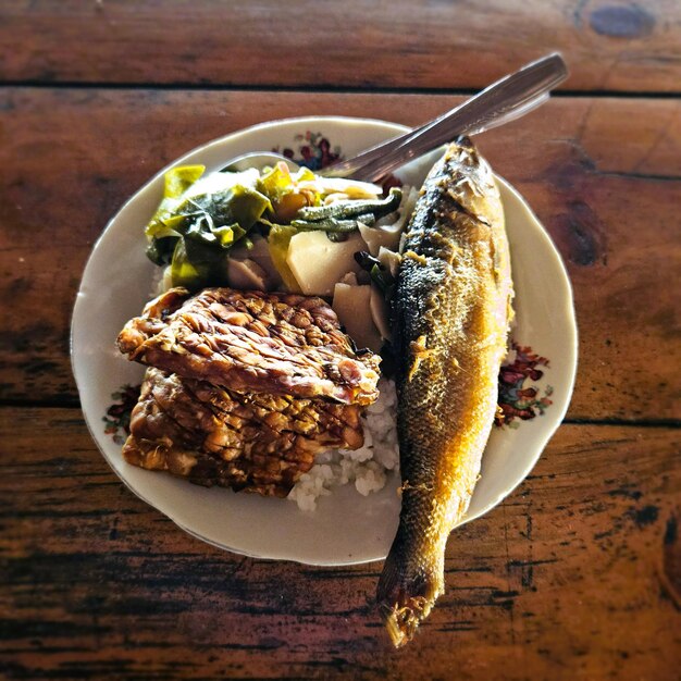 Photo one of the traditional javanese foods consists of rice lodeh vegetables fried tempeh and milkfish