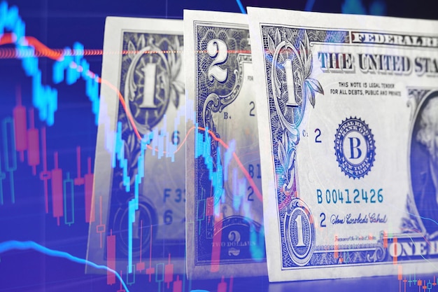 주식 시장 차트 배경의 어두운 표면에 있는 1달러 및 2달러 지폐