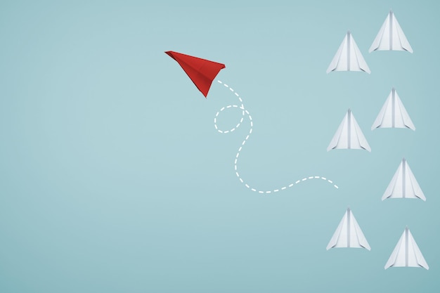 one unique red paper airplane in different way of the group of white
 paper airplane on light blue background . business or design creative ideal leadership concept .