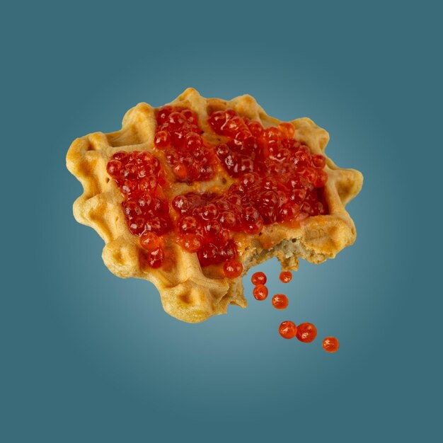 one Viennese waffle with red caviar on a blue background flying food