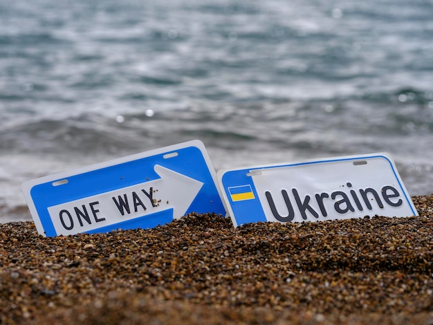 one way and  Ukraine sign on the beach