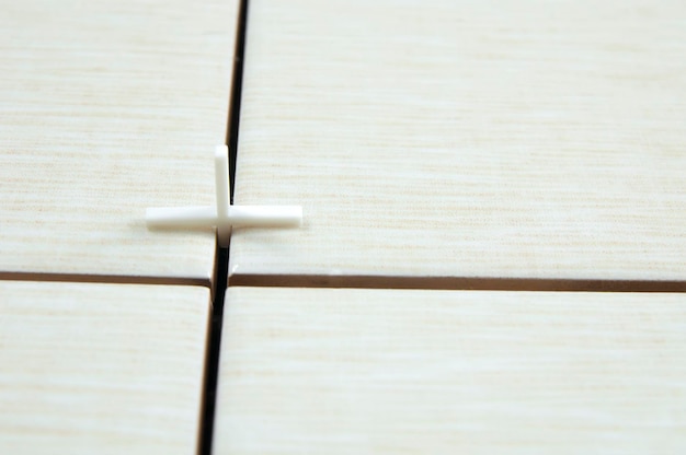 타일 타일의 조인트에 있는 하나의 흰색 십자가, 타일 놓기 수리의 개념